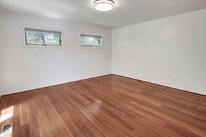 Unfurnished room featuring dark wood-type flooring and baseboards