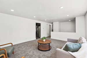Living area with carpet floors, recessed lighting, and a textured ceiling