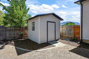 View of shed featuring a fenced backyard and a mountain view