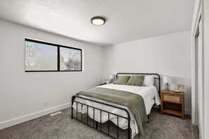 Bedroom with carpet and a textured ceiling