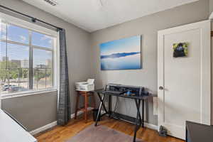 Office area with a textured ceiling and light wood-style floors