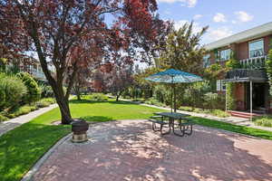 View of property's community featuring a yard and a patio area