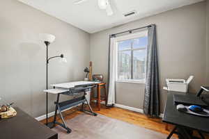 Office area featuring light wood-style floors and a textured ceiling