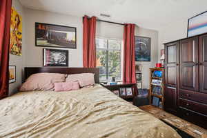 Bedroom with a textured ceiling and a ceiling fan