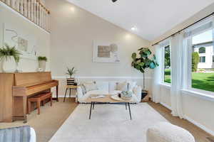 Carpeted living room with recessed lighting and high vaulted ceiling
