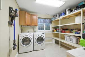 Washroom featuring cabinet space, independent washer and dryer, and a textured ceiling