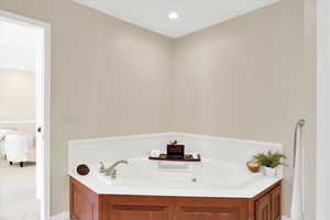 Full bathroom featuring a garden tub and recessed lighting