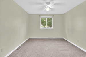 Empty room featuring light carpet and ceiling fan
