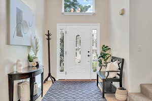 Foyer entrance featuring carpet flooring and a high ceiling