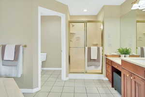 Full bath featuring light tile patterned floors, vanity, a shower stall, and recessed lighting