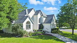 View of front facade with a front yard and stucco siding