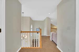 Corridor featuring light carpet, an upstairs landing, and recessed lighting