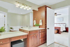 Full bath featuring light tile patterned floors, vanity, connected bathroom, and ceiling fan
