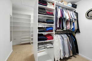 Very Spacious Main closet with light colored carpet