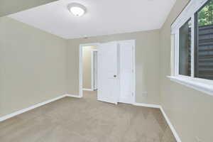 Unfurnished bedroom featuring light carpet and a textured ceiling