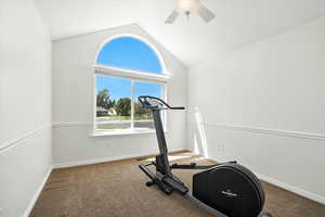 Exercise area with vaulted ceiling, carpet, and ceiling fan