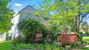 View of property exterior with roof with shingles, stucco siding, and a yard