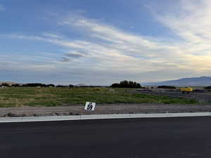 View of asphalt street featuring curbs, a rural view, and a mountain view