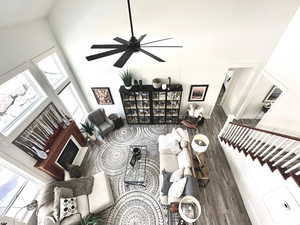 Living area featuring a high ceiling, wood finished floors, and ceiling fan