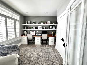 Office space featuring built in study area, light wood-type flooring, a textured ceiling, and recessed lighting