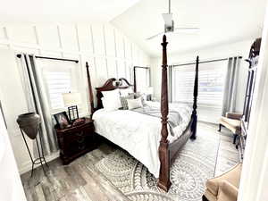 Bedroom featuring light wood finished floors, vaulted ceiling, and a ceiling fan