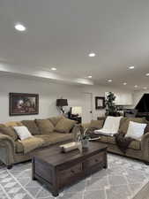 Living area with recessed lighting and light colored carpet