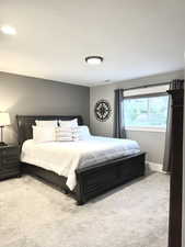 Bedroom with light carpet and baseboards