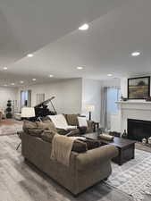 Living room featuring light wood finished floors, a fireplace, and recessed lighting