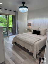 Primary bedroom with wood finished floors, exterior deck