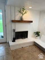 Unfurnished living room featuring a fireplace with raised hearth
