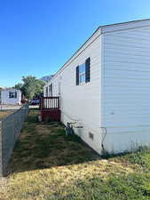 View of home's exterior with crawl space and a wooden deck