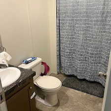 Bathroom with vanity, light tile patterned floors, and curtained shower