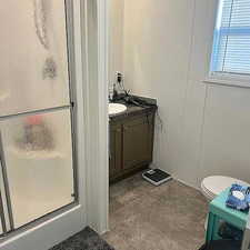 Bathroom featuring vanity and a shower with door