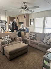 Carpeted living area featuring ceiling fan, washer / dryer, and a textured ceiling