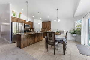 Dining space featuring vaulted ceiling, light tile patterned floors, a chandelier, and recessed lighting