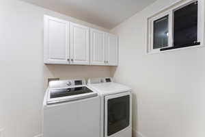 Washroom featuring cabinet space and washer and dryer