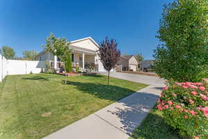 Obstructed view of property featuring a porch, concrete driveway, an attached garage, and a gate
