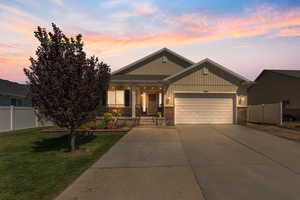 Craftsman-style house with brick siding, covered porch, a garage, and driveway