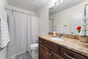 Bathroom with vanity, light tile patterned floors, and curtained shower