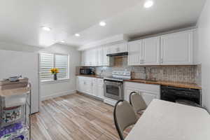 Kitchen featuring white cabinetry, black appliances, recessed lighting, backsplash, and dark countertops