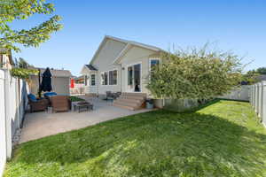 Back of property featuring a fenced backyard, a patio, entry steps, and a fire pit