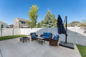Fenced backyard featuring a patio and an outdoor living space with a fire pit