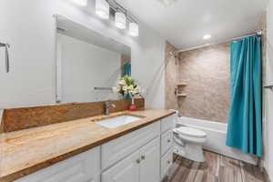Bathroom featuring shower / bath combo, vanity, light wood-style flooring, and recessed lighting