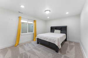 Bedroom with light colored carpet and recessed lighting