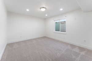 Unfurnished room with light colored carpet and recessed lighting
