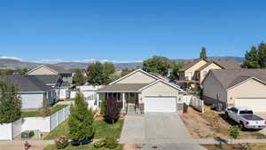 Traditional-style house with a residential view, a garage, concrete driveway, a porch, and brick siding
