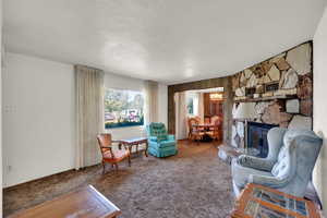 Carpeted living room with a textured ceiling and a fireplace