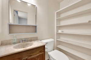 Half bathroom with vanity and toilet