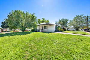 View of side of property featuring a yard and concrete driveway