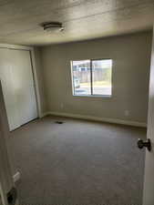 Unfurnished bedroom with carpet and a closet
